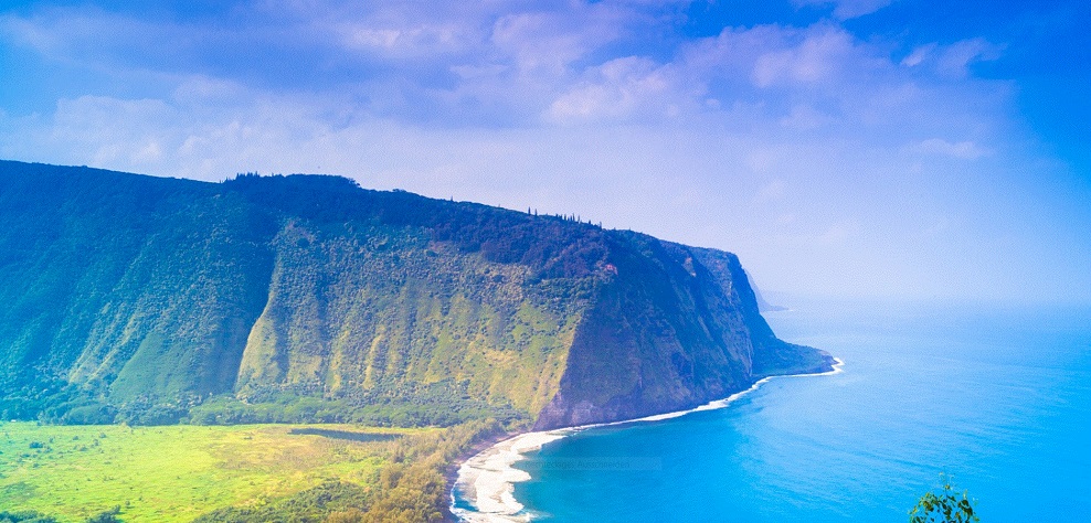 Steile, grün bewachsene Küstenklippen Hawaiis mit Blick auf den Pazifik