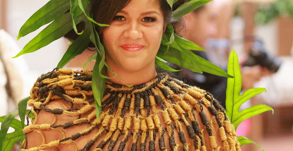 Frau in traditioneller hawaiianischer Tracht mit grünem Blattkranz und geflochtenem Naturfaser-Halsschmuck