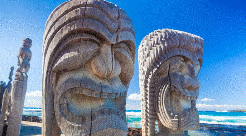 Geschnitzte hölzerne Tiki-Statuen am Meer, traditionelle hawaiianische Kunst